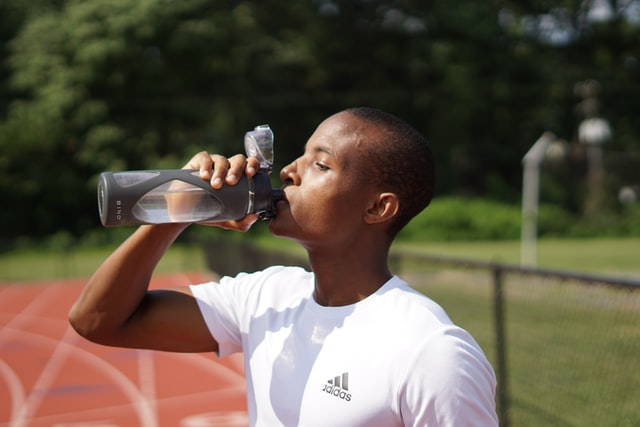 man drinking water after a run